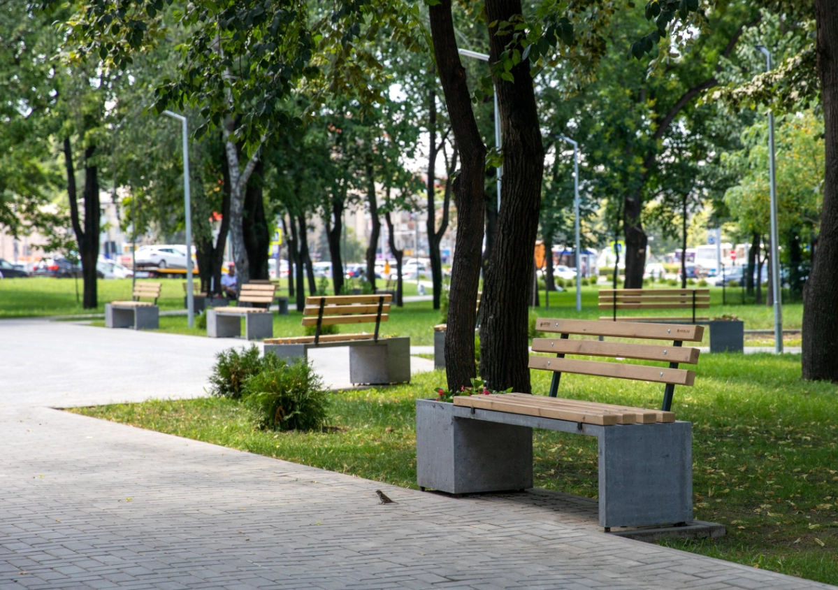 Бетонная скамейка с деревянными спинками и горшками