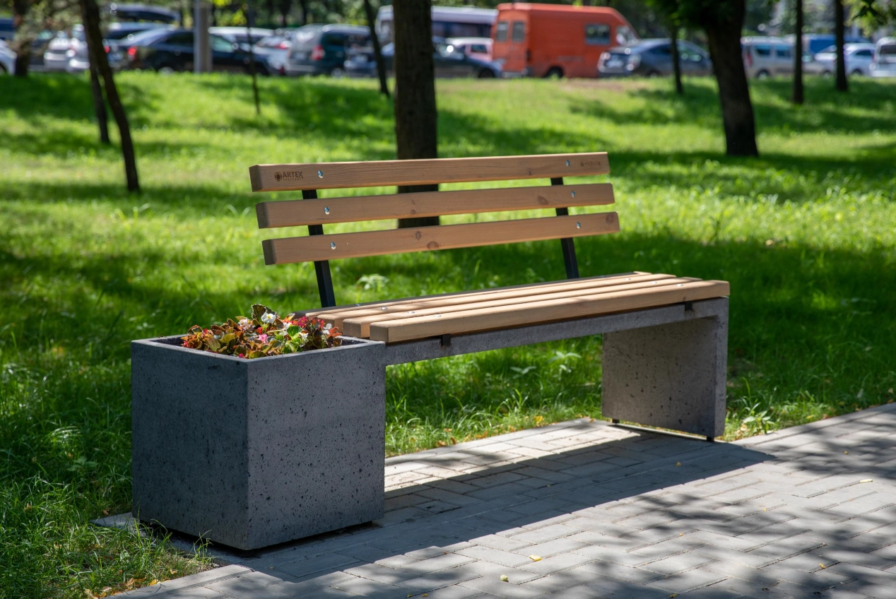 Бетонная скамейка с деревянными спинками и горшками